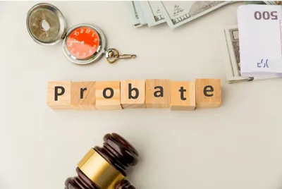 Wooden blocks spelling probate beside a gavel, pocket watch, and money