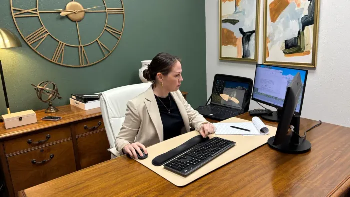 Attorney Maggie Mauer working at her desk in the firm's Texas office