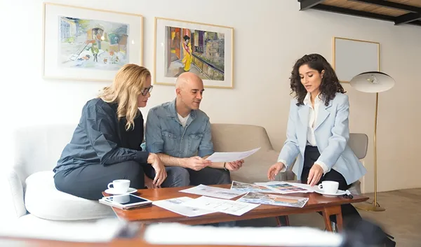 Advisor reviewing documents with couple at coffee table